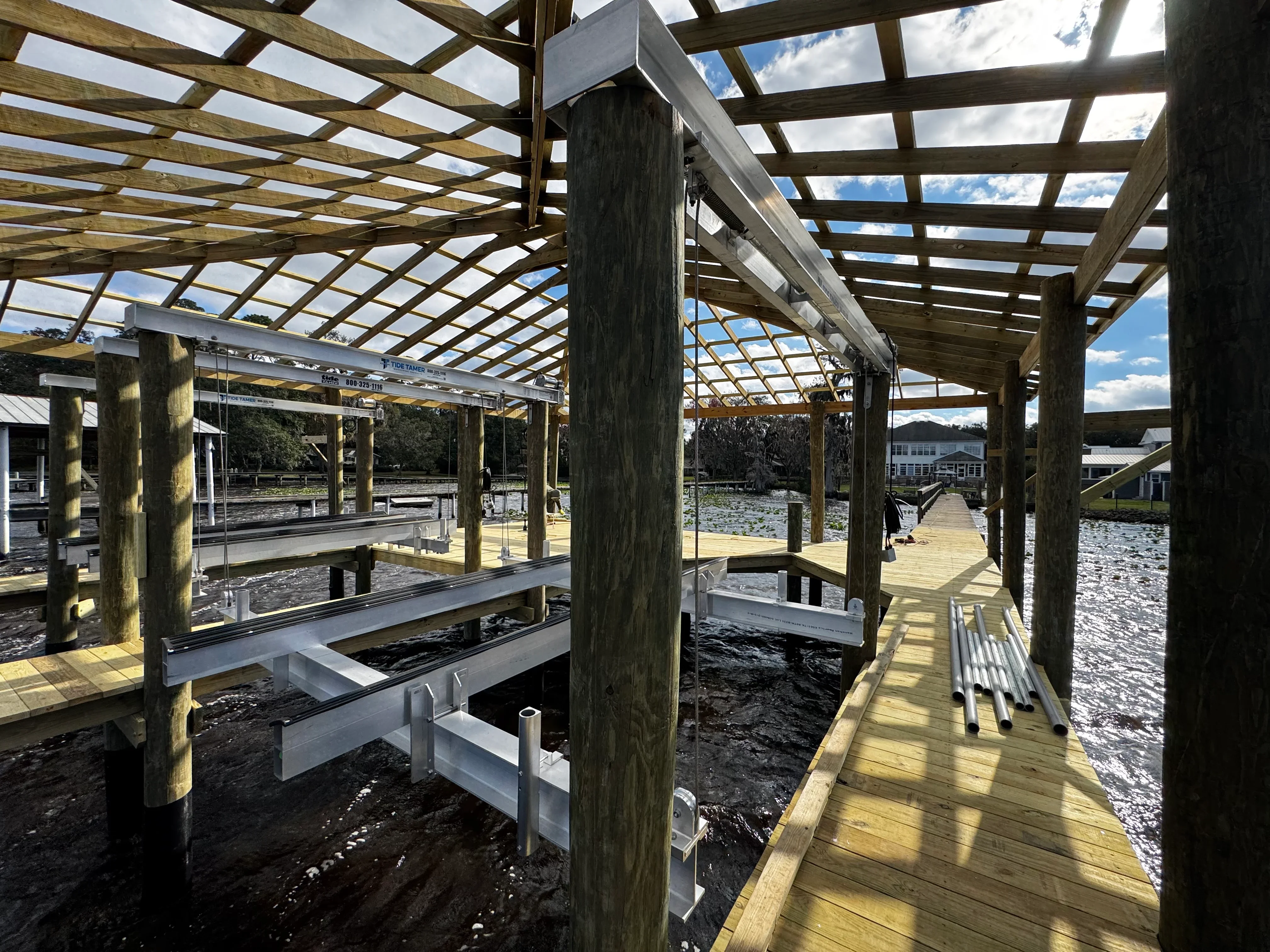 Timber pergola with lattice roof, aluminum railings, and composite deck over water