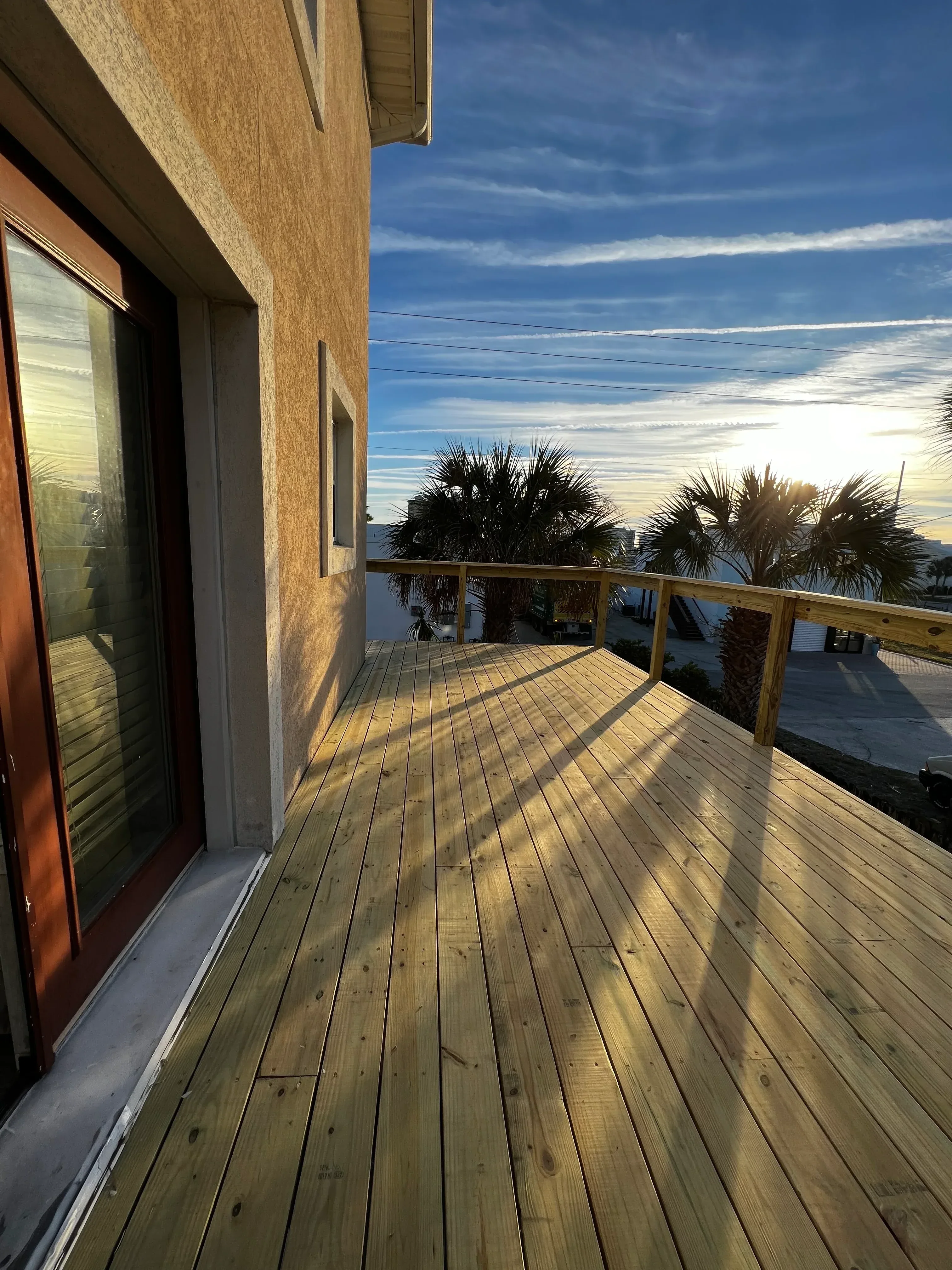 Newly constructed wood deck and horizontal siding on residential structure with concrete foundation