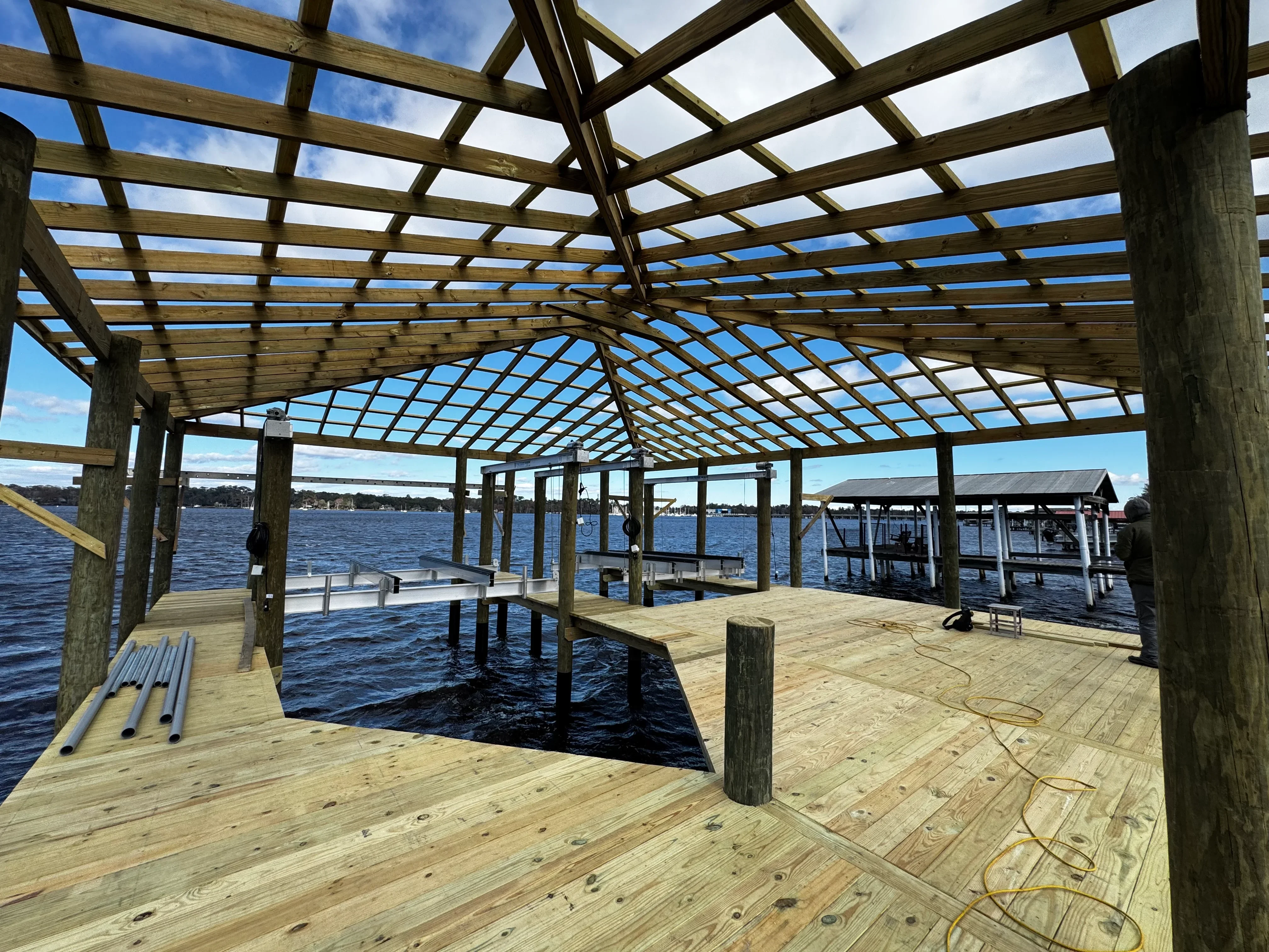 Timber-frame boat house with lattice roof, pressure-treated decking, and water views
