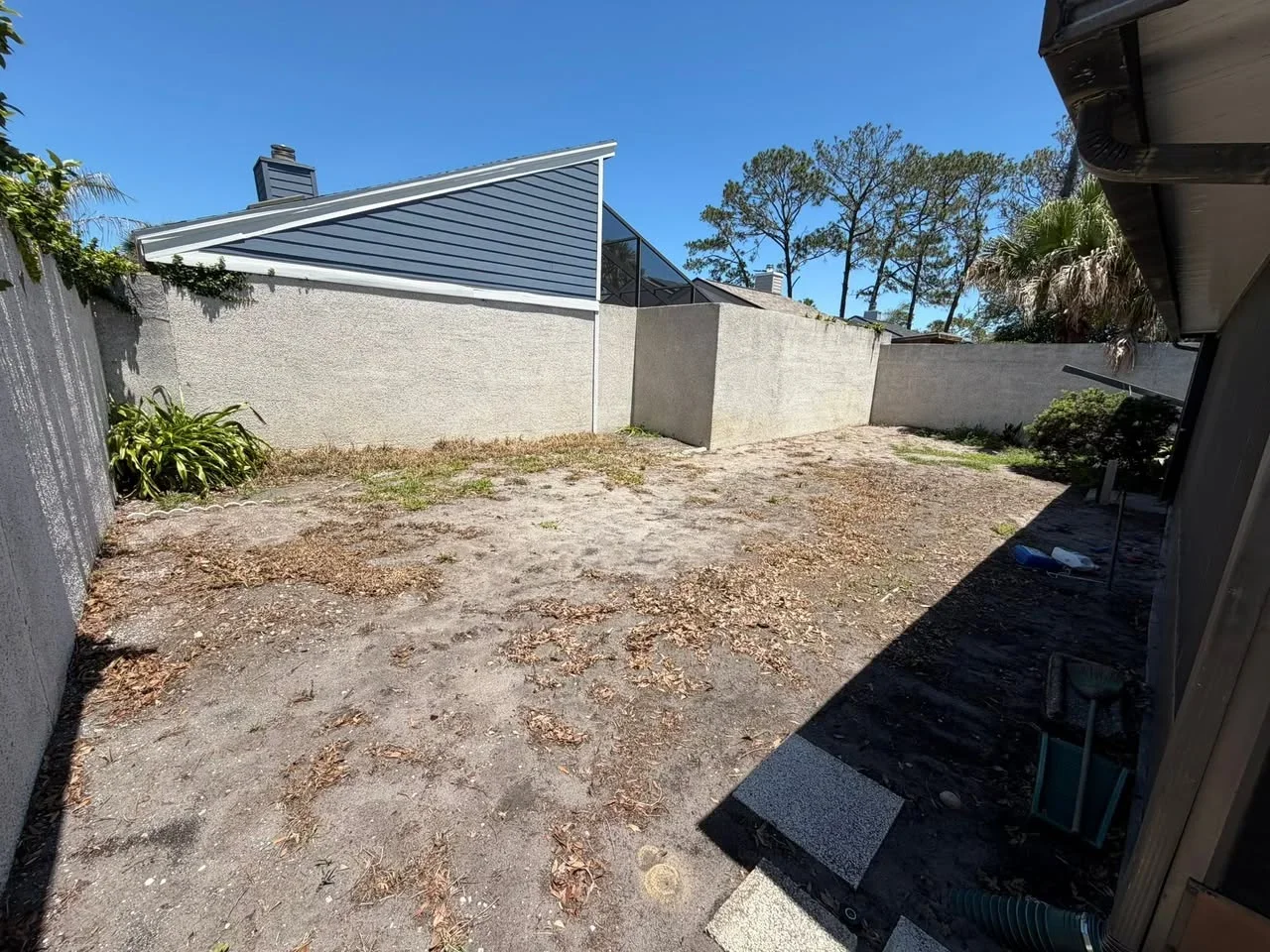 Concrete retaining walls and prepared patio base with gravel in residential backyard