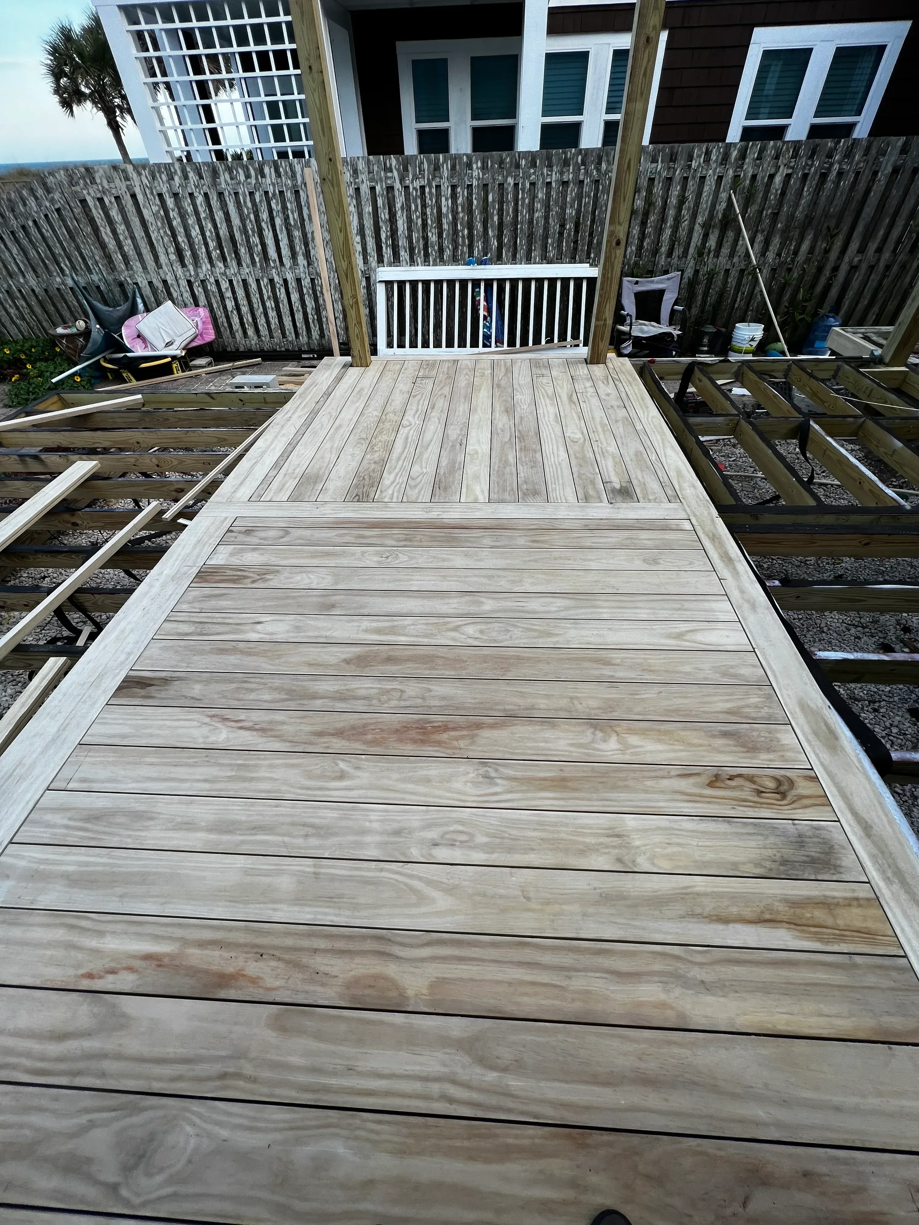 Horizontal wood siding and deck construction with pressure-treated lumber framing and railing system
