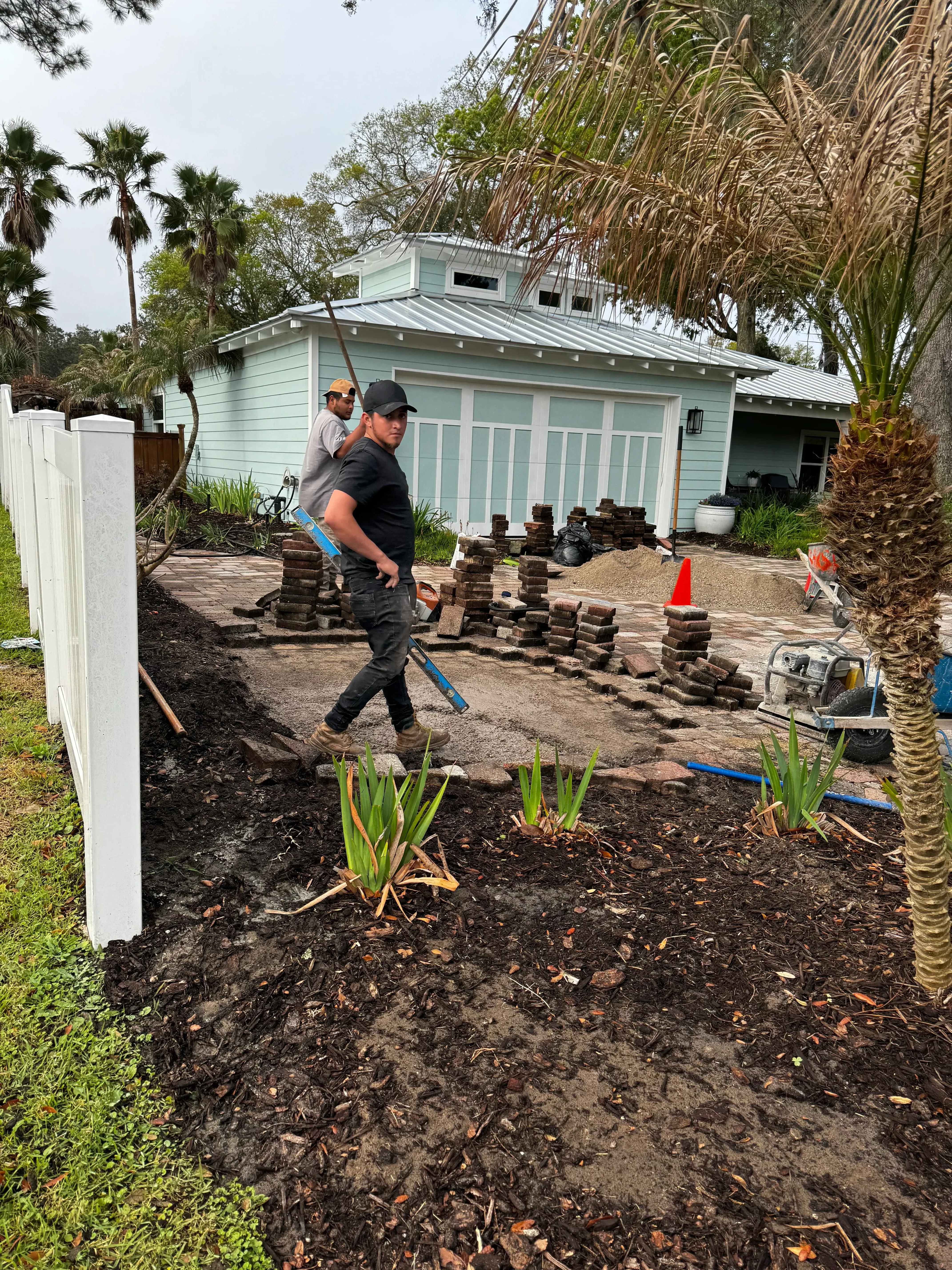 Concrete paver installation with drainage pipes and grading work on residential property