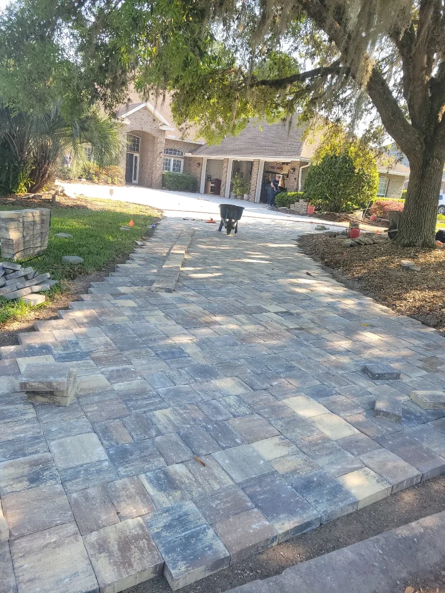 Gray and tan permeable concrete pavers installed in herringbone pattern for residential driveway