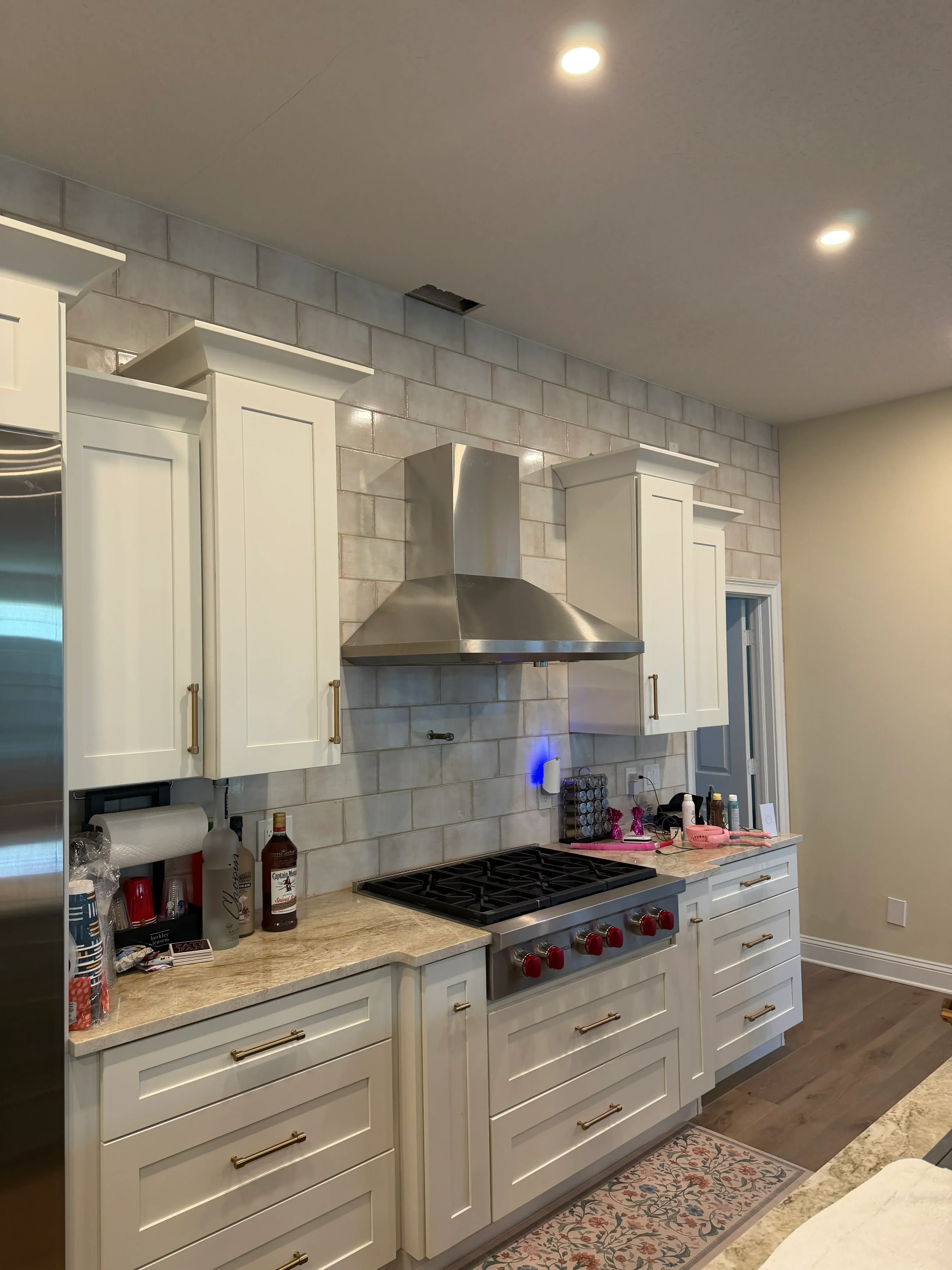 White cabinetry, subway tile flooring, granite counters, and recessed lighting in renovated kitchen and bath