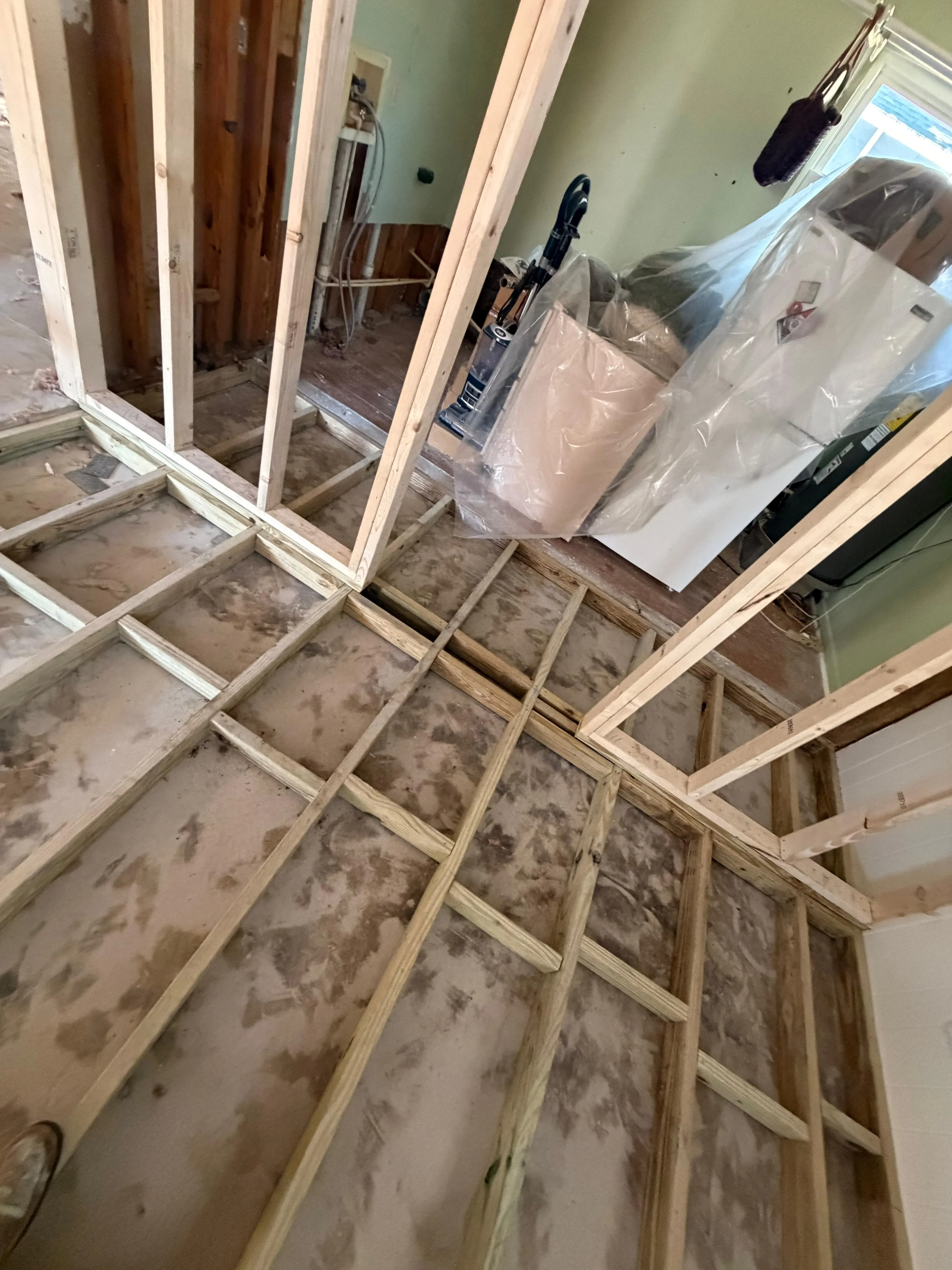Interior framing with wooden studs, headers, and drywall substrate in progress
