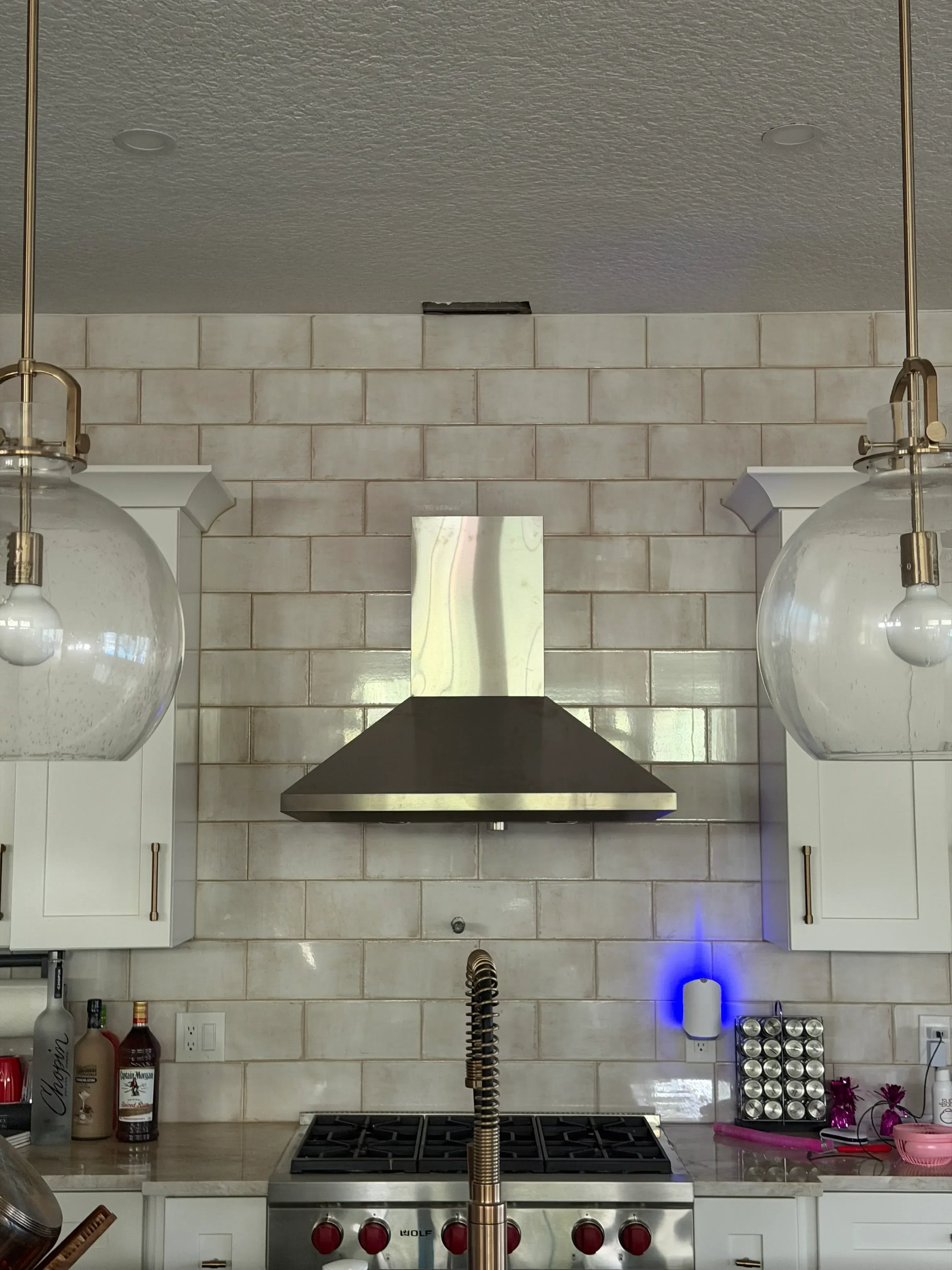 Bathroom with subway tile walls, dual vessel sinks, brass fixtures, and custom cabinetry